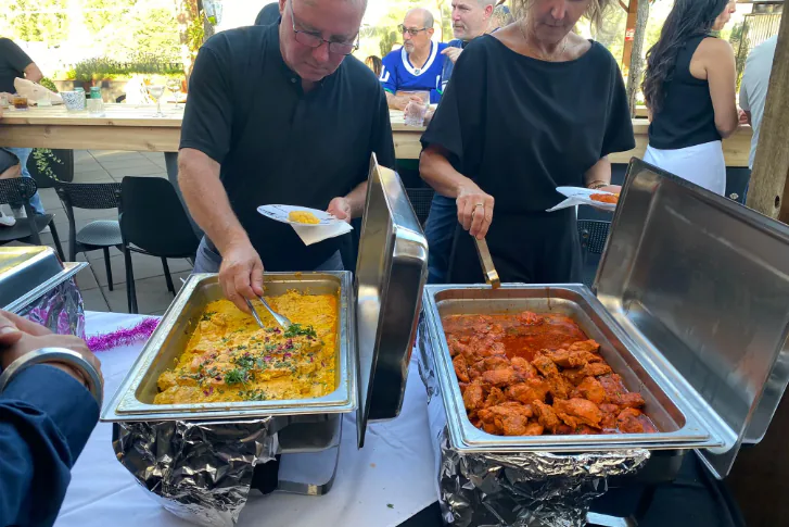Guests moving through an Indian buffet line at an event